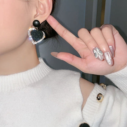 Svarta hjärthängeörhängen i guld